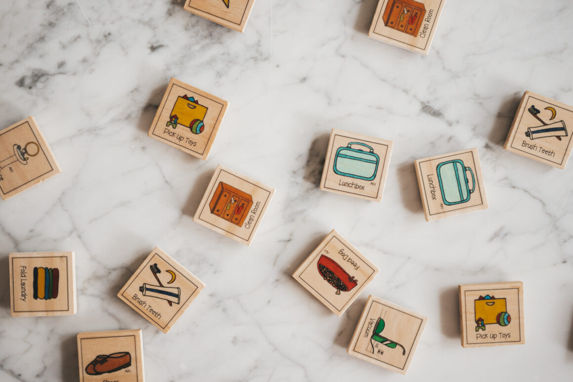 a set of wooden tiles with pictures of chores on them on a marble table