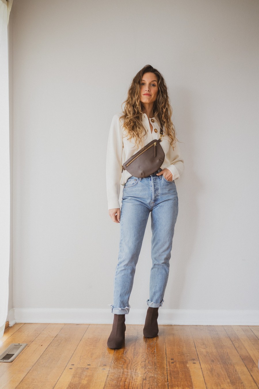 Sézane Betty Cardigan outfit with light wash cropped jeans, brown ankle boots, and a brown sling bag