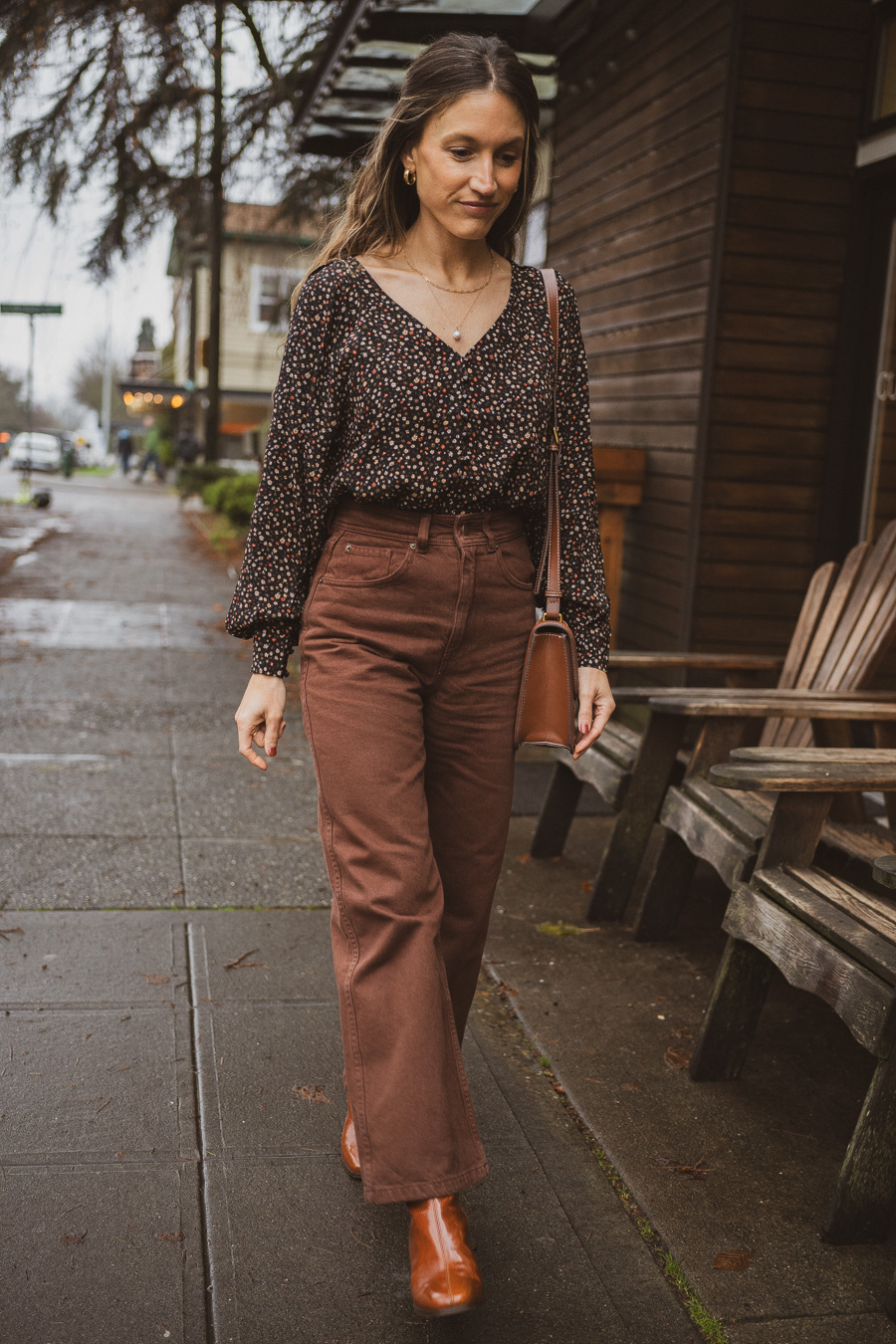 black and brown outfit with a black floral blouse, brown cropped pants, and polished camel boots