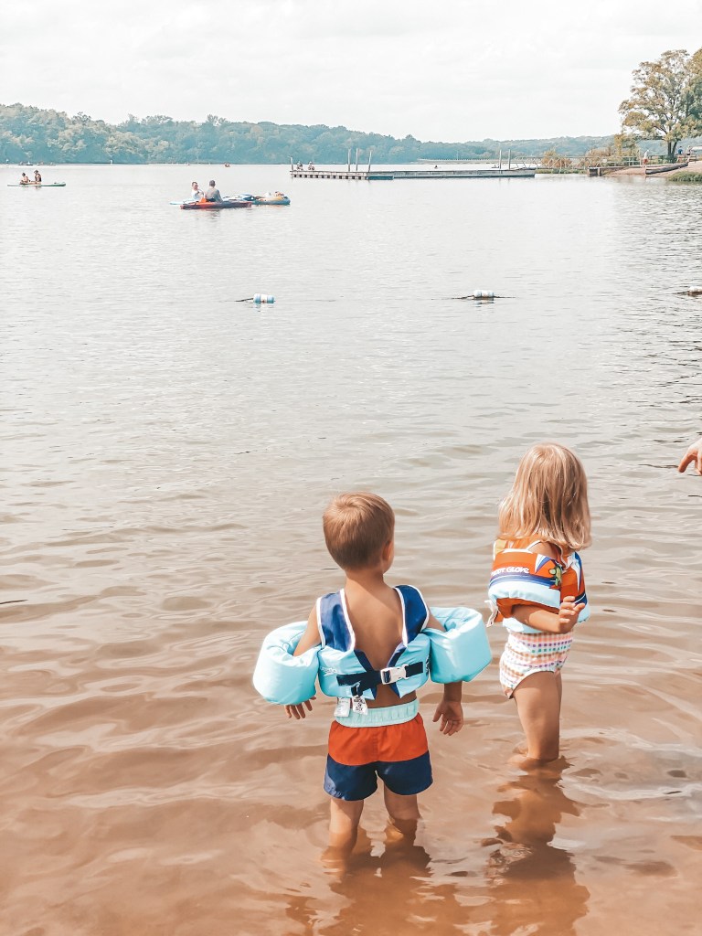 two young kids standing in the water at the Shawnee Mission Park Beach