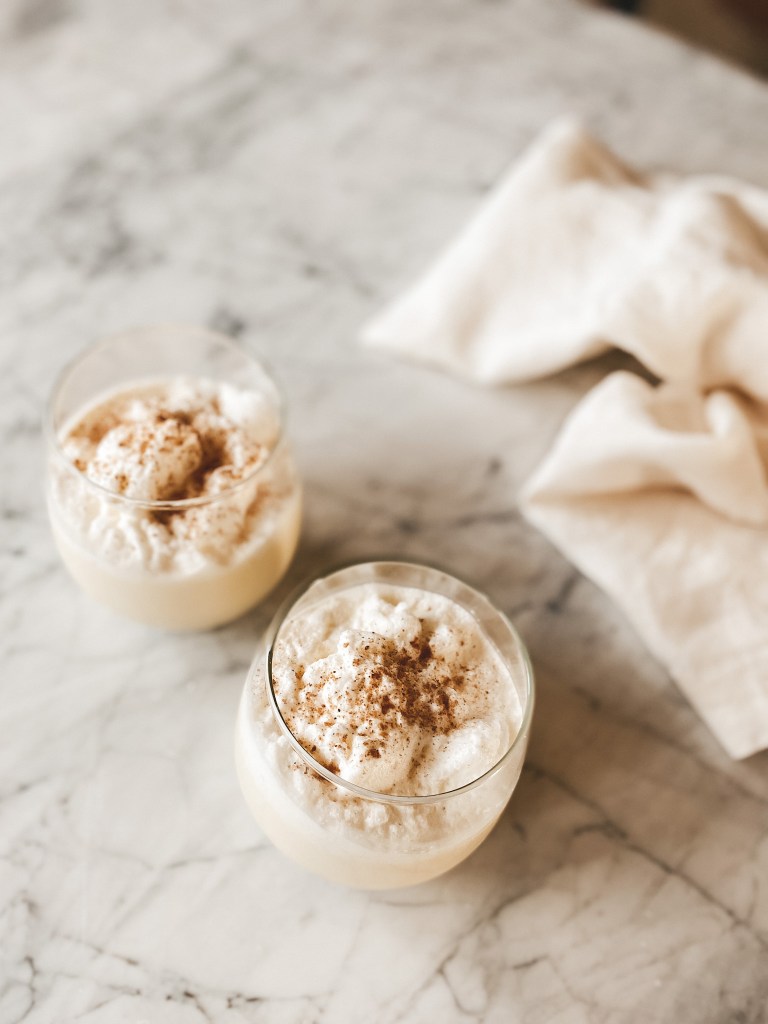 a white marble table with 2 glasses of egg nog 